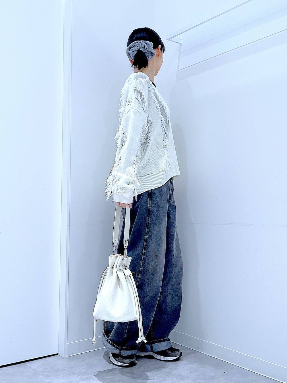 ブラック系のTシャツ/カットソー、ブラック系のデニムパンツ、ホワイト系のショルダーバッグを着用したレディースの春コーディネートの4枚目の写真