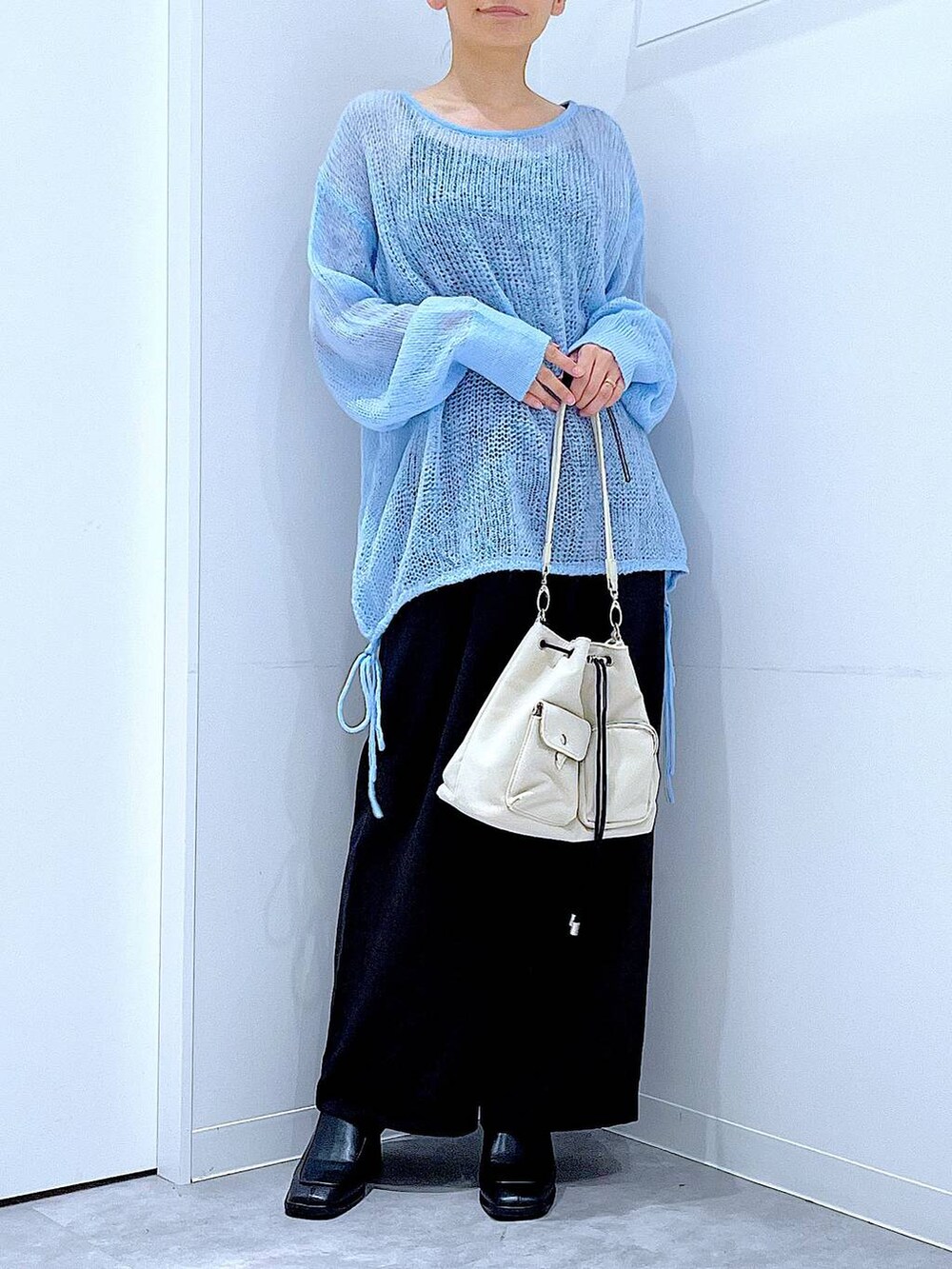 ブラック系のその他パンツ、ホワイト系のショルダーバッグ、ブラック系のブーツを着用したレディースの冬コーディネートの6枚目の写真