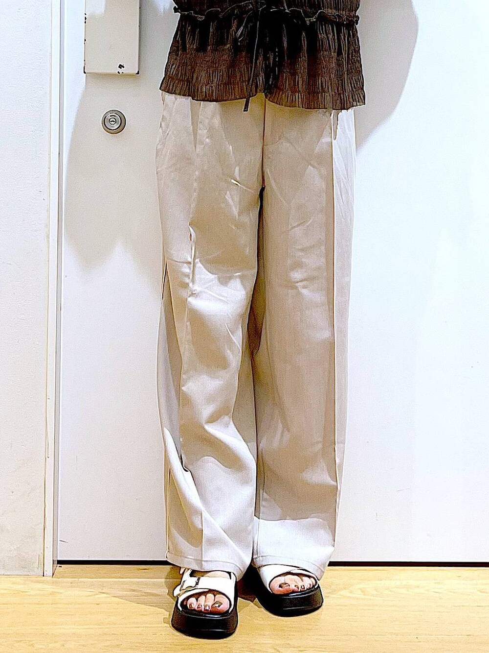 ホワイト系のサンダル、ベージュ系のスラックス、ピンク系のショルダーバッグを着用したレディースの秋コーディネートの8枚目の写真