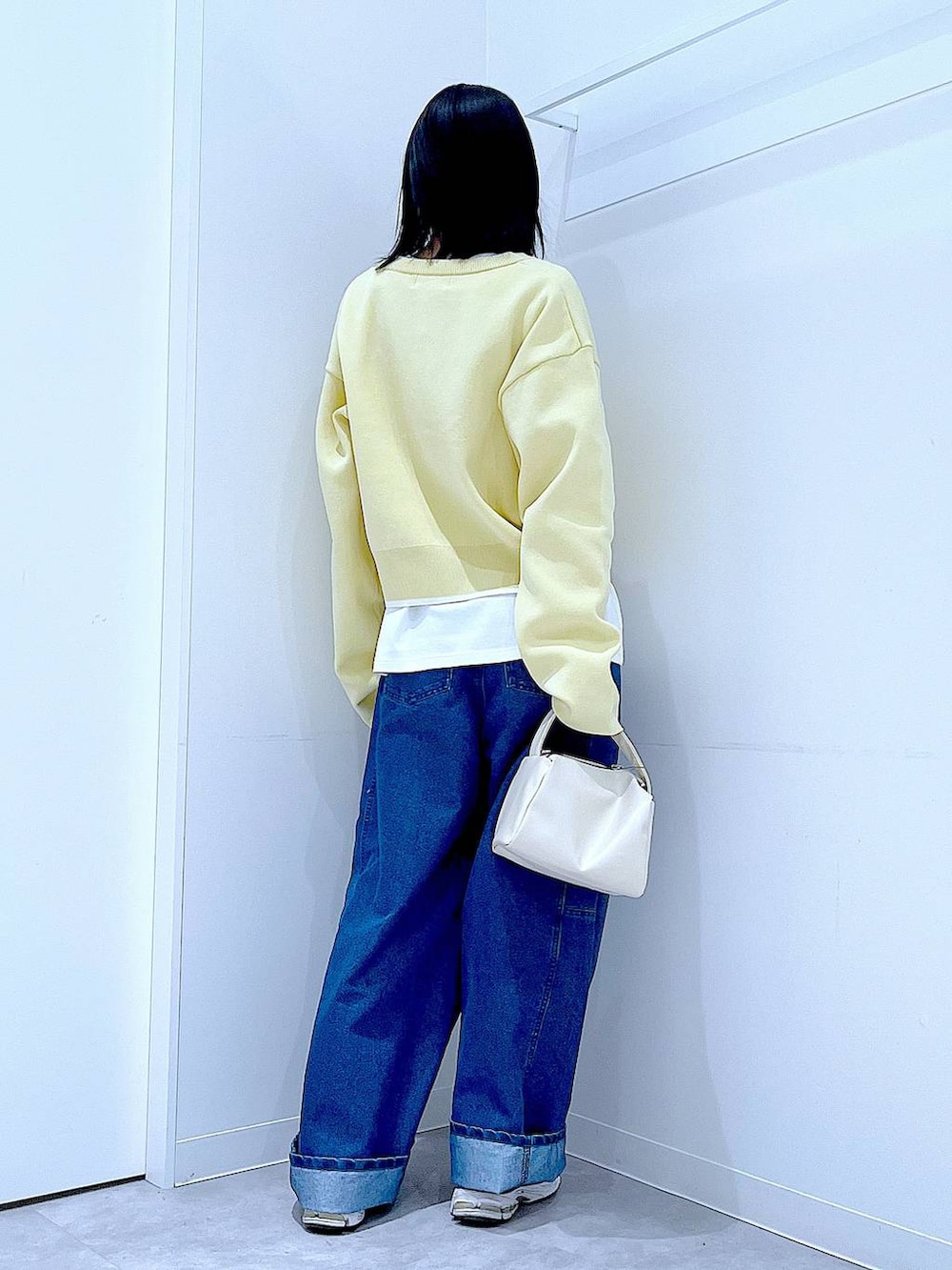 ホワイト系のショルダーバッグ、ホワイト系のTシャツ/カットソー、ブルー系のデニムパンツを着用したレディースの春コーディネートの5枚目の写真