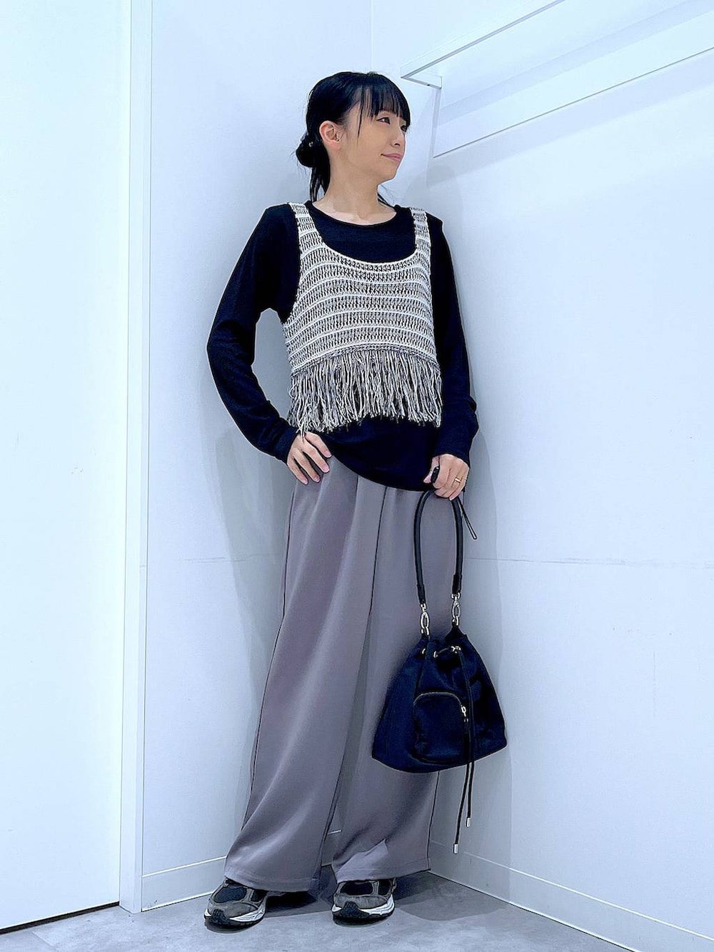 ブラック系のTシャツ/カットソー、グレー系のベスト、グレー系のその他パンツを着用したレディースの春コーディネートの2枚目の写真