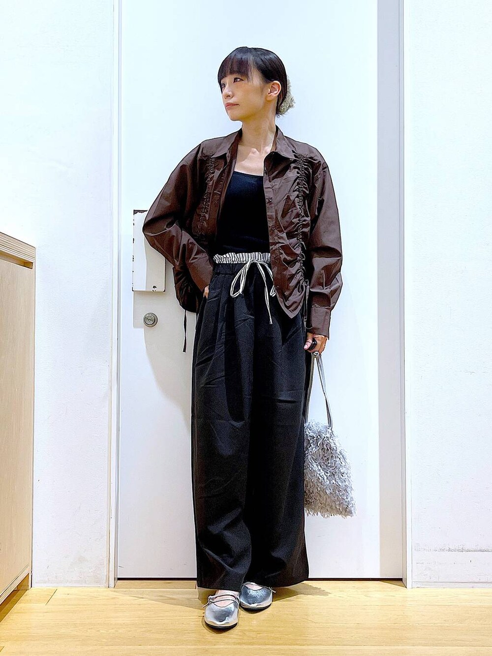 グレー系のショルダーバッグ、シルバー系のパンプス、ブラウン系のシャツ/ブラウスを着用したレディースの秋コーディネートの2枚目の写真