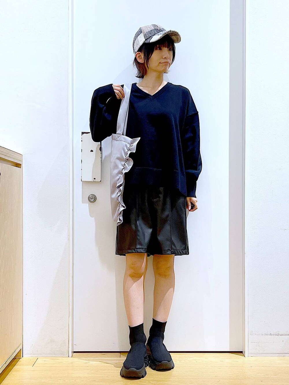 ブラック系のブーツ、グレー系のトートバッグ、ブラック系のその他パンツを着用したレディースの秋コーディネートの2枚目の写真