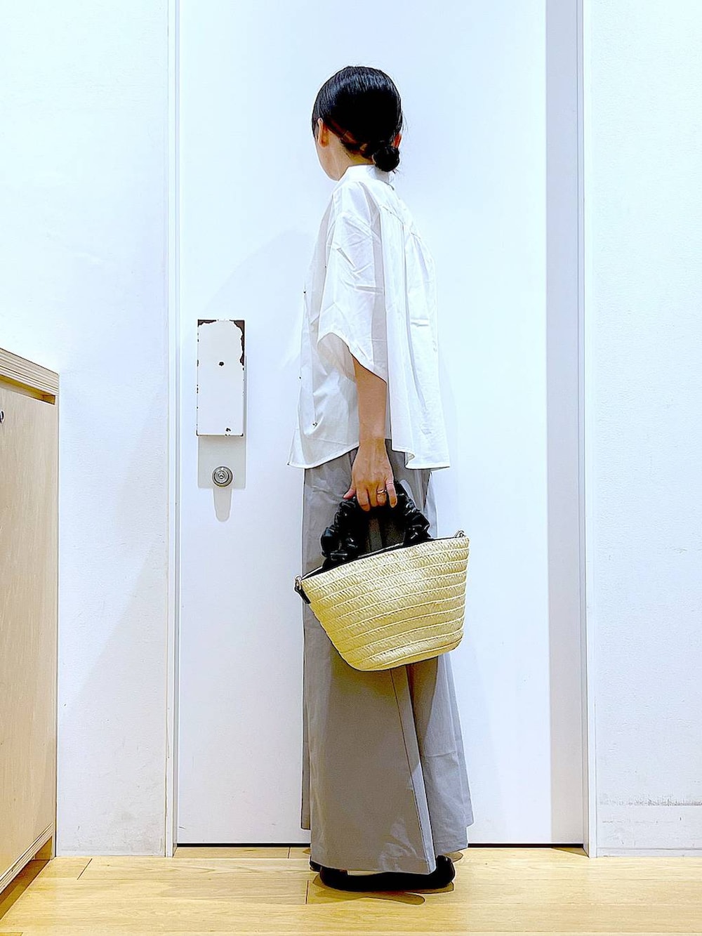 ホワイト系のサンダル、ホワイト系のショルダーバッグ、グレー系のスカートを着用したレディースの夏コーディネートの3枚目の写真