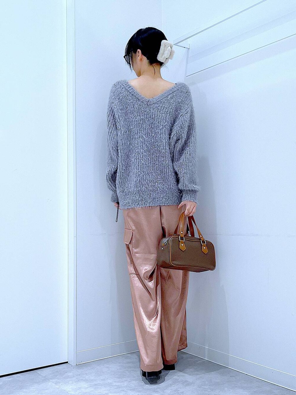 ブラック系のブーツ、ブラウン系のショルダーバッグ、ピンク系のカーゴパンツを着用したレディースの冬コーディネートの5枚目の写真