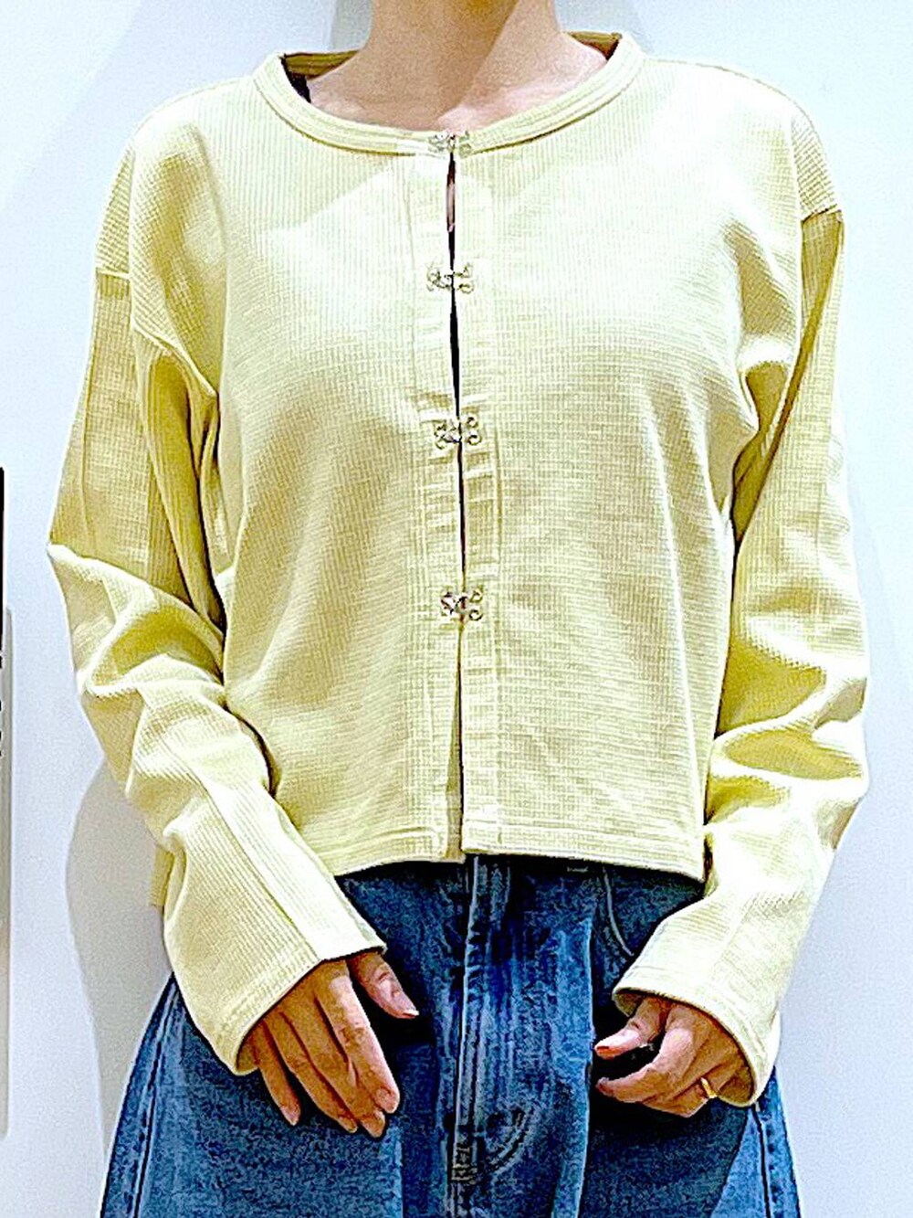 シルバー系のトートバッグ、ブルー系のデニムパンツ、シルバー系のパンプスを着用したレディースの春コーディネートの7枚目の写真