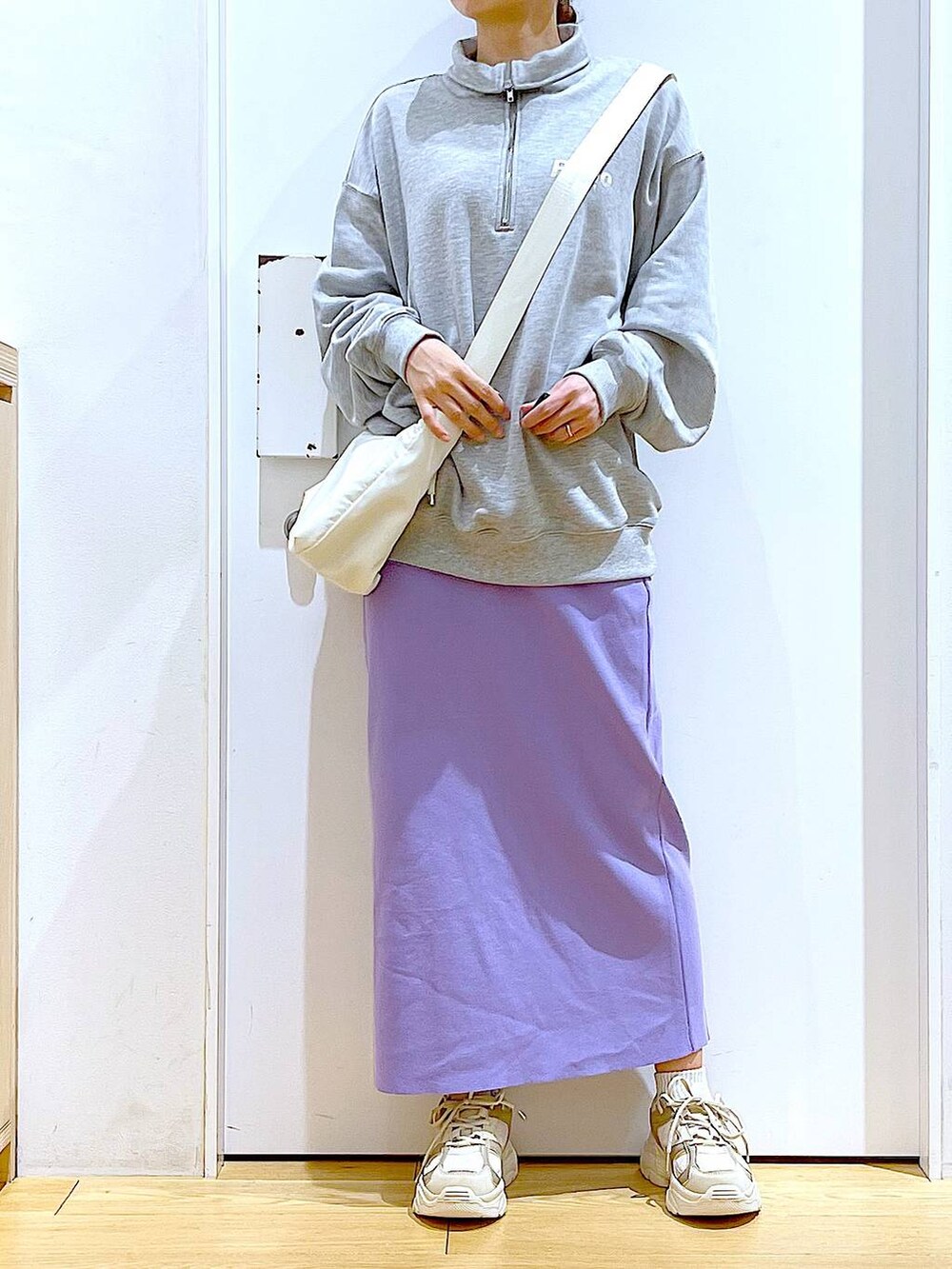 グレー系のスウェット、ベージュ系のスニーカー、ホワイト系のショルダーバッグを着用したレディースの春コーディネートの6枚目の写真