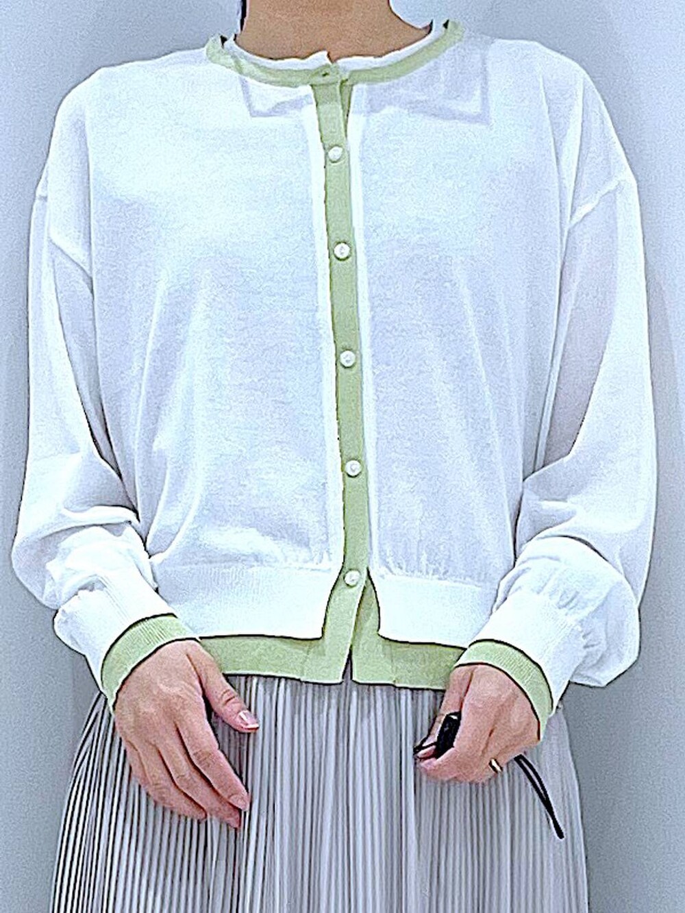 ホワイト系のショルダーバッグ、ベージュ系のスカート、ホワイト系のカーディガン/ボレロを着用したレディースの春コーディネートの7枚目の写真