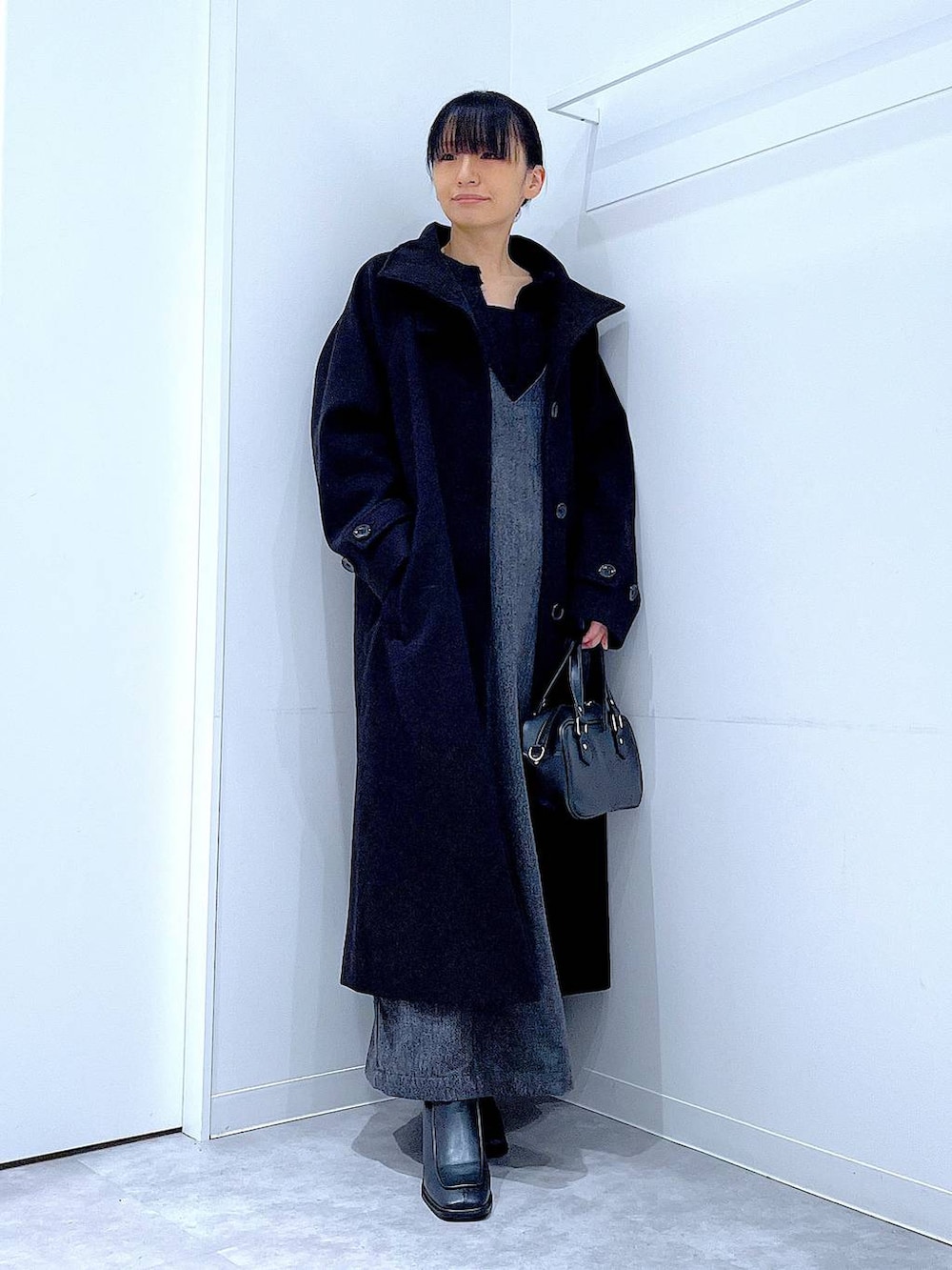 ブラック系のその他アウター、ブラック系のブーツ、ブラック系のニット/セーターを着用したレディースの冬コーディネートの2枚目の写真