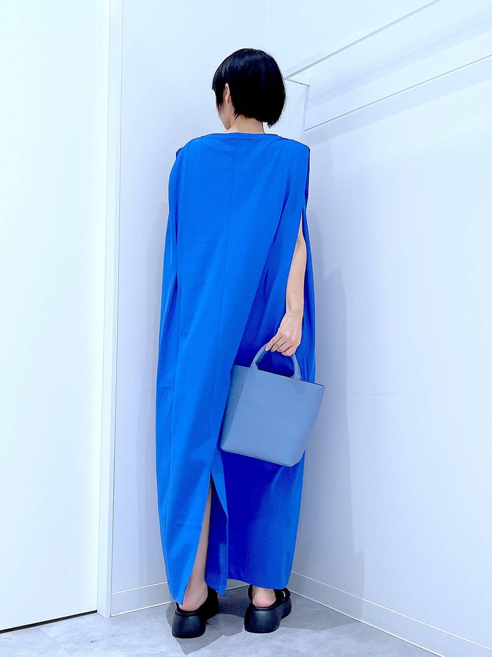 ブラック系のサンダル、ブルー系のワンピース、ブルー系のショルダーバッグを着用したレディースの夏コーディネートの5枚目の写真