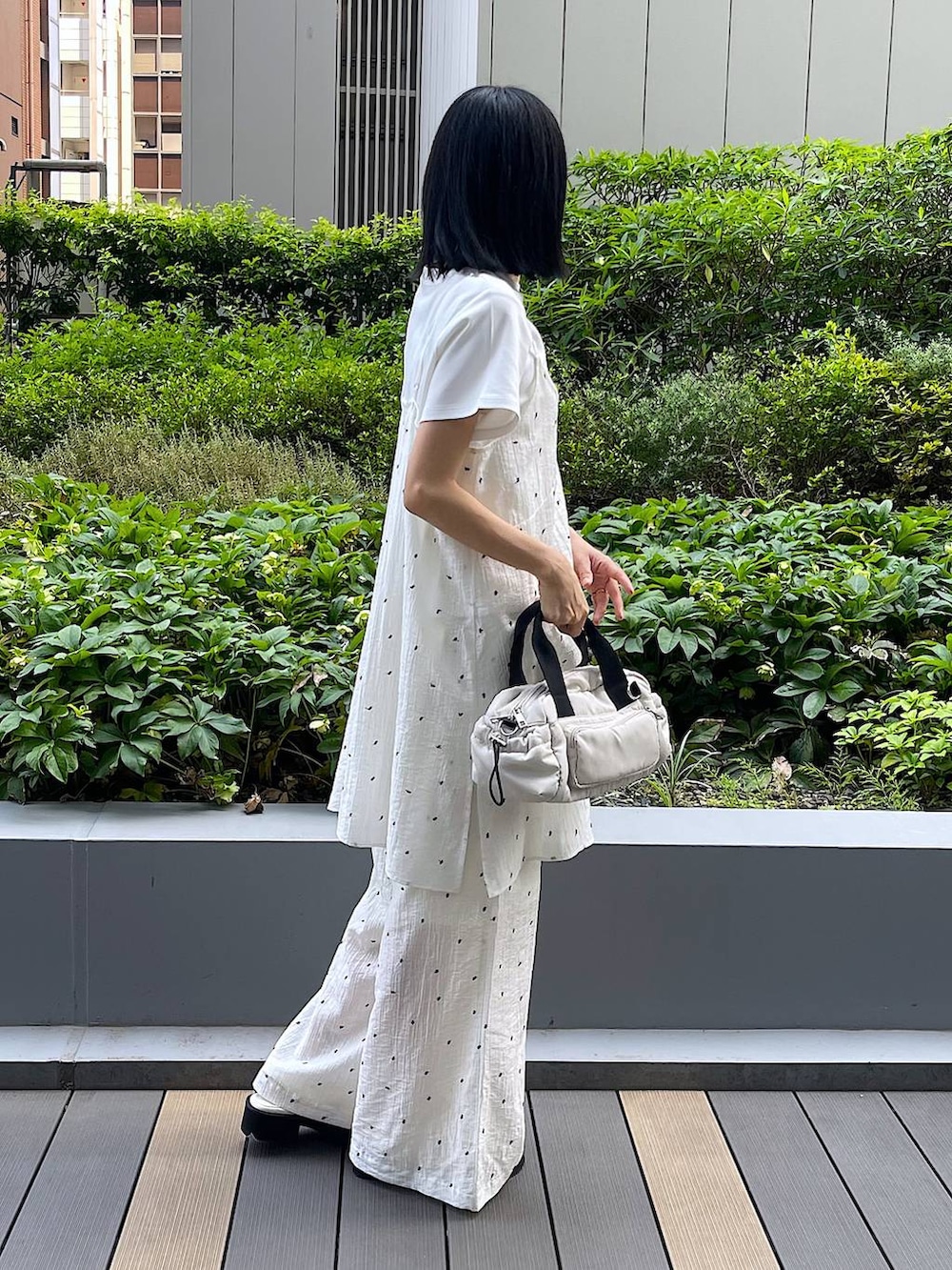 ホワイト系のサンダル、ホワイト系のTシャツ/カットソー、ホワイト系のショルダーバッグを着用したレディースの夏コーディネートの5枚目の写真