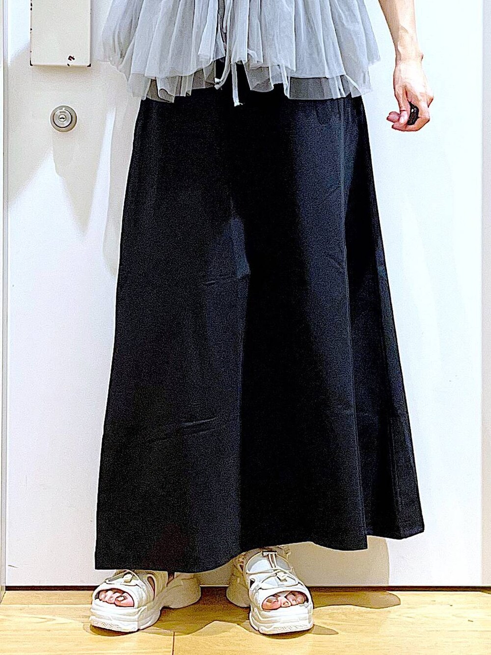 ホワイト系のショルダーバッグ、ホワイト系のサンダル、ブラック系のスカートを着用したレディースの夏コーディネートの8枚目の写真