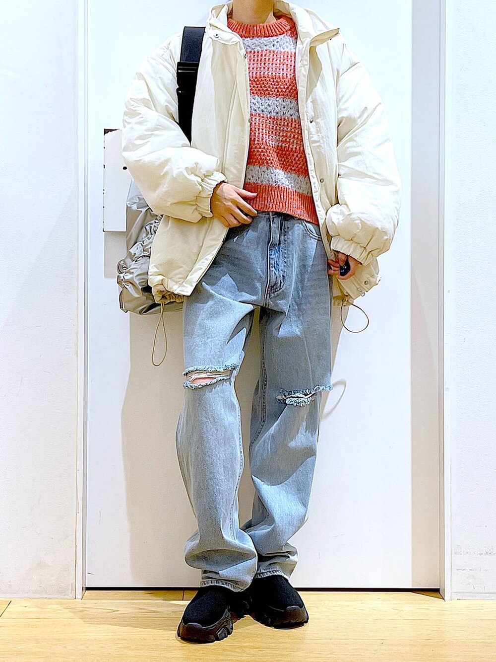 ブラック系のブーツ、ブルー系のデニムパンツ、シルバー系のショルダーバッグを着用したレディースの冬コーディネートの6枚目の写真