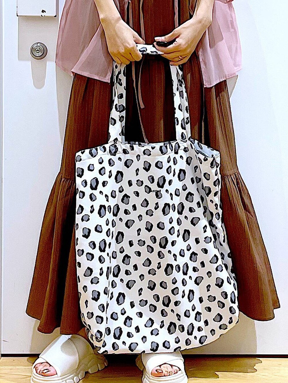 ホワイト系のサンダル、ベージュ系のワンピース、ホワイト系のトートバッグを着用したレディースの夏コーディネートの9枚目の写真