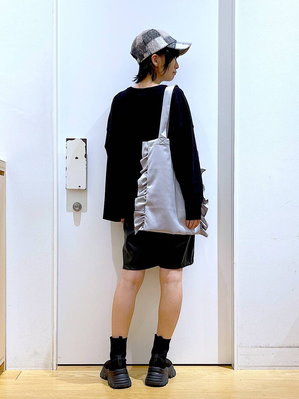 ブラック系のブーツ、グレー系のトートバッグ、ブラック系のその他パンツを着用したレディースの秋コーディネートの5枚目の写真