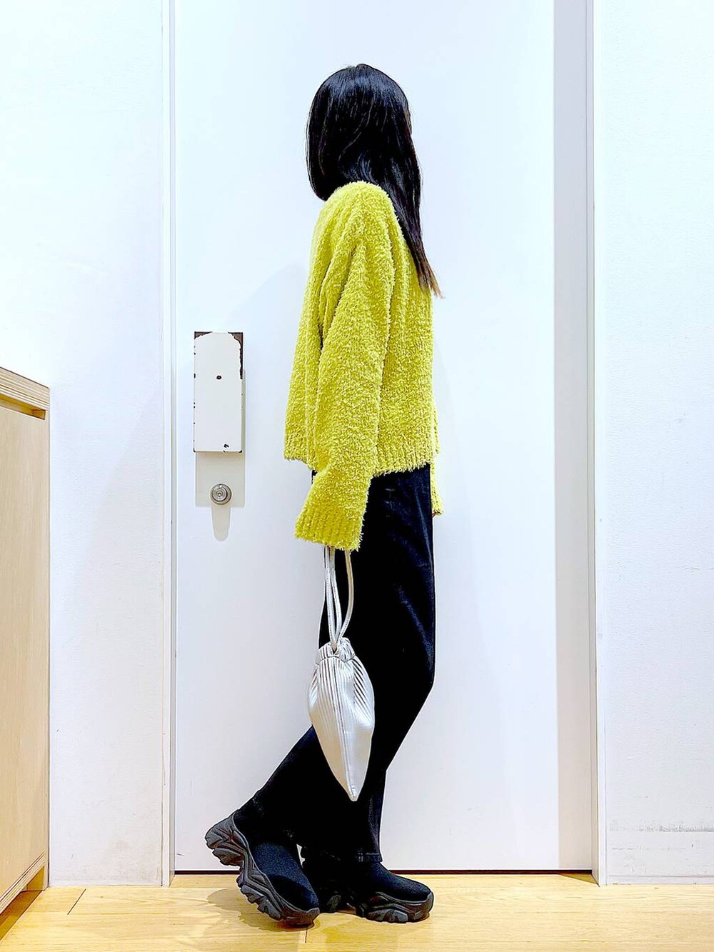 グリーン系のニット/セーター、グレー系のデニムパンツ、シルバー系のショルダーバッグを着用したレディースの冬コーディネートの4枚目の写真