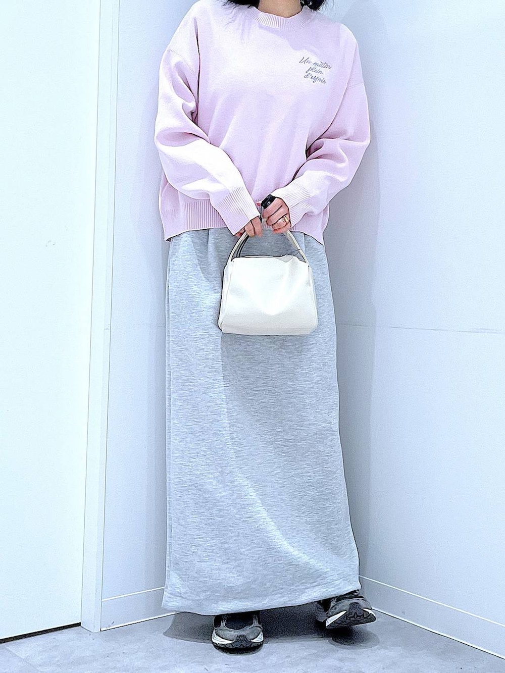 ホワイト系のショルダーバッグ、ピンク系のニット/セーター、グレー系のスカートを着用したレディースの冬コーディネートの6枚目の写真