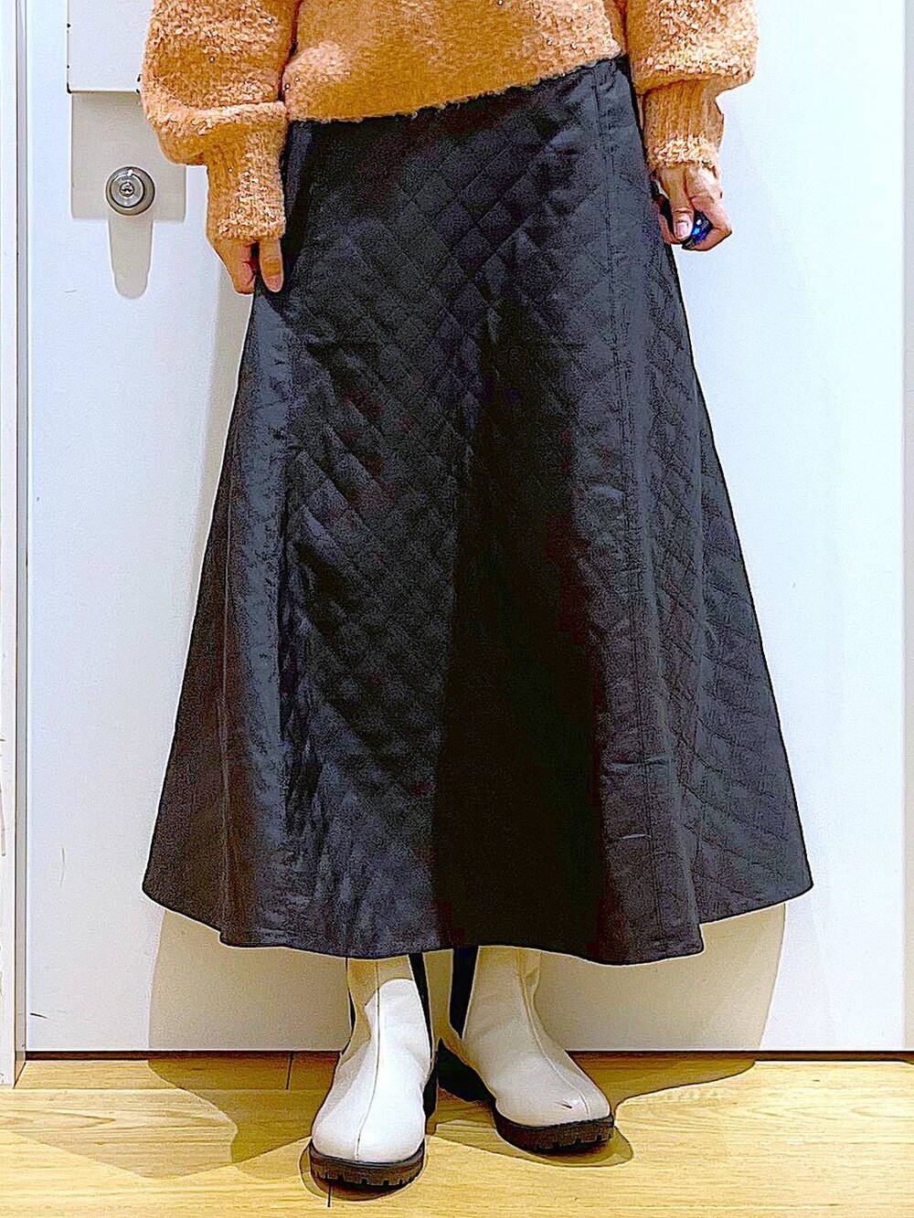 ベージュ系のブーツ、ベージュ系のショルダーバッグ、ブラック系のスカートを着用したレディースの冬コーディネートの8枚目の写真
