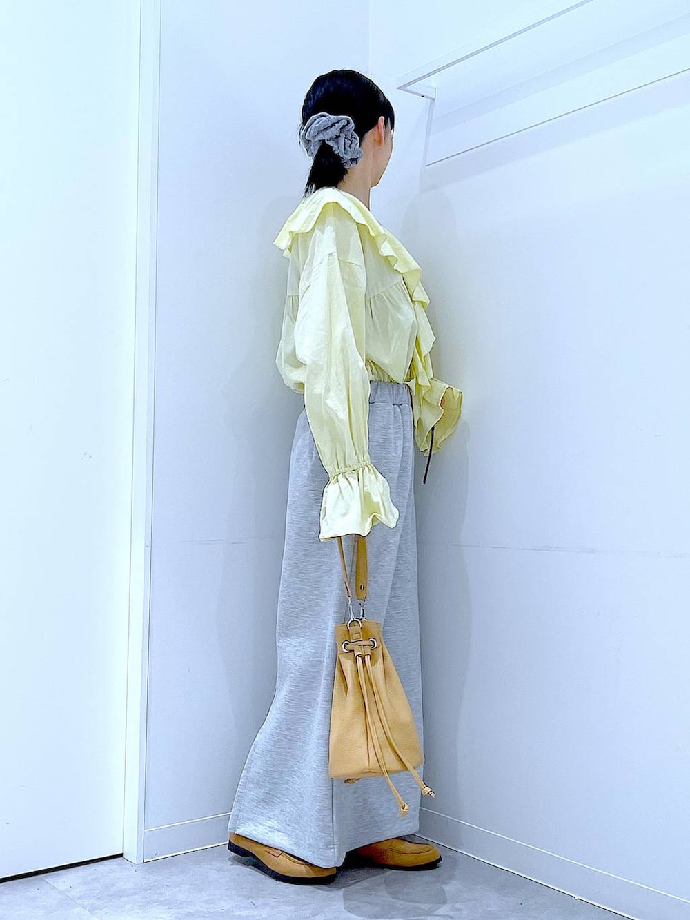 グレー系のスカート、ベージュ系のローファー、ブラウン系のショルダーバッグを着用したレディースの冬コーディネートの4枚目の写真