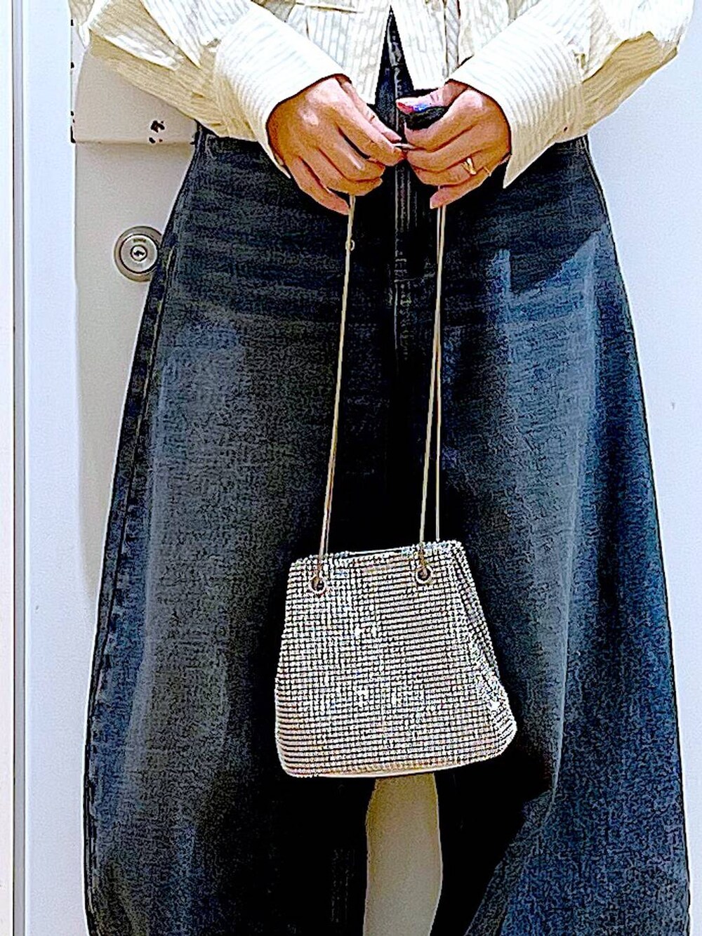 グレー系のショルダーバッグ、ブルー系のデニムパンツ、ホワイト系のスニーカーを着用したレディースの春コーディネートの9枚目の写真