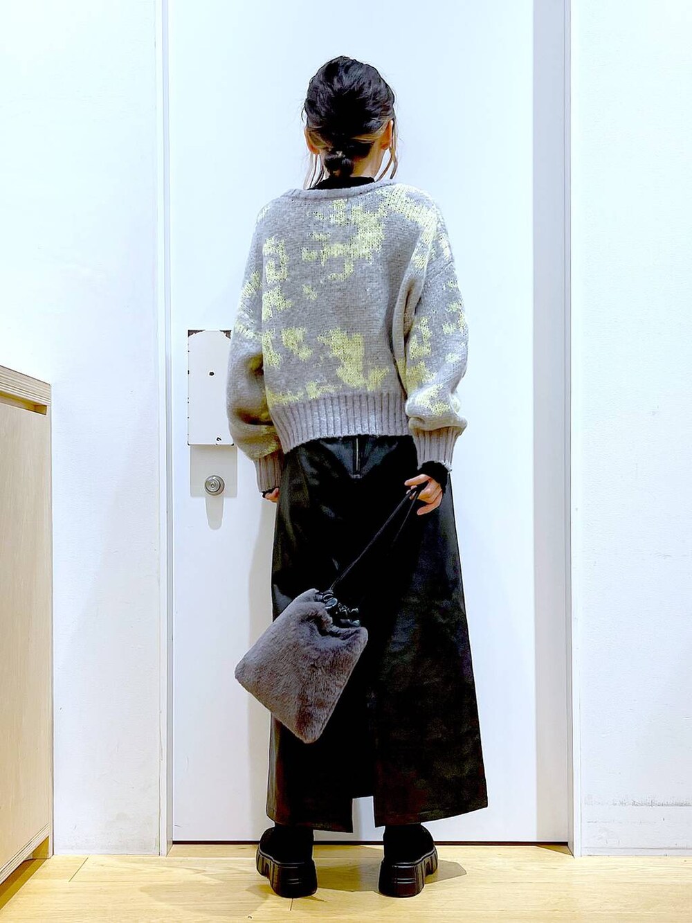 ブラック系のTシャツ/カットソー、グレー系のショルダーバッグ、ブラック系のブーツを着用したレディースの冬コーディネートの5枚目の写真