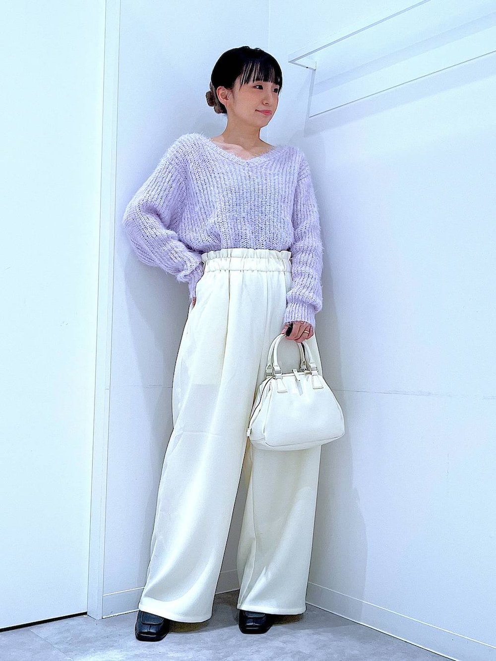 ブラック系のブーツ、ホワイト系のショルダーバッグ、パープル系のニット/セーターを着用したレディースの冬コーディネートの2枚目の写真