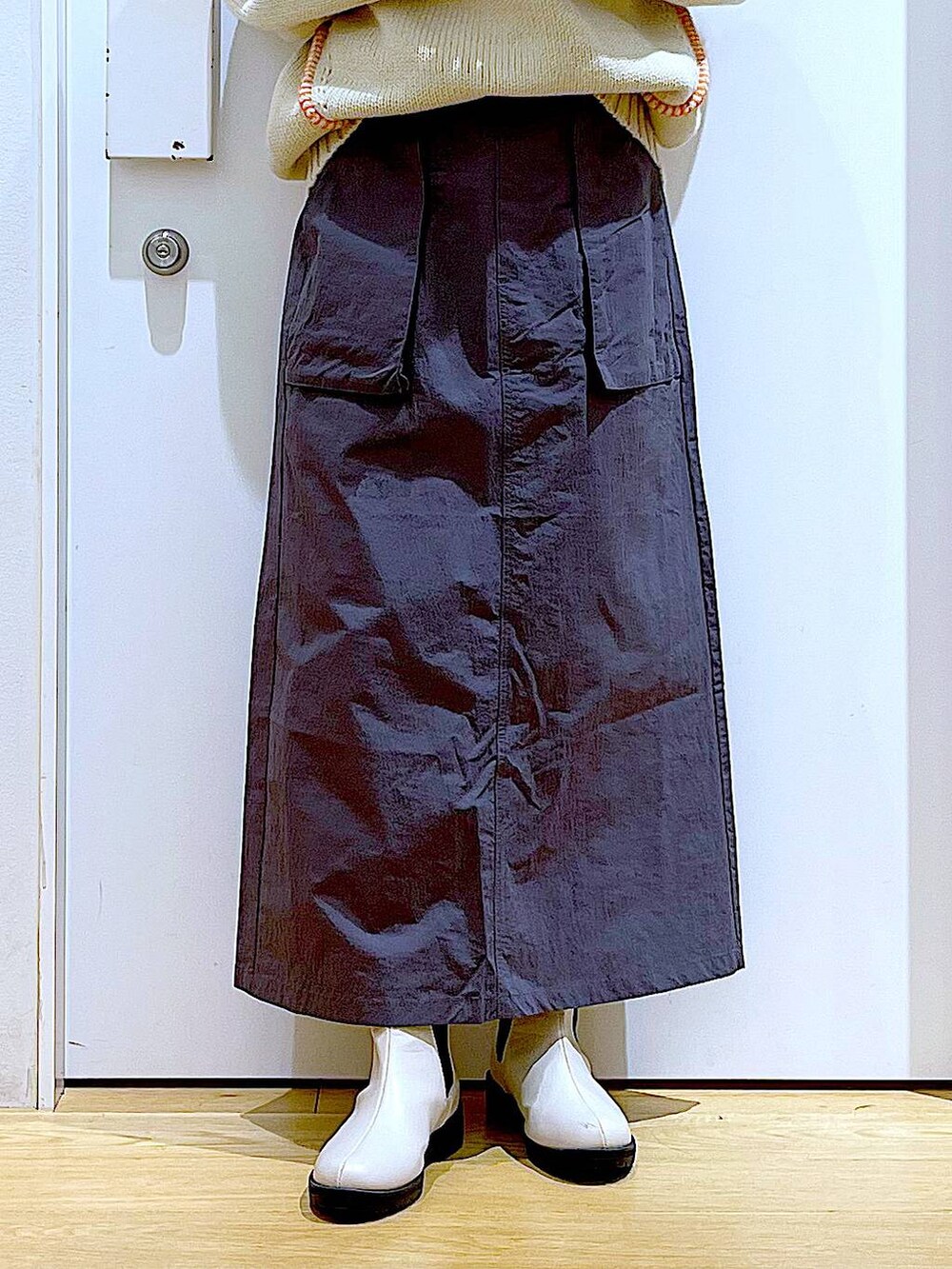 ブラック系のTシャツ/カットソー、ベージュ系のブーツ、ブラック系のショルダーバッグを着用したレディースの冬コーディネートの8枚目の写真