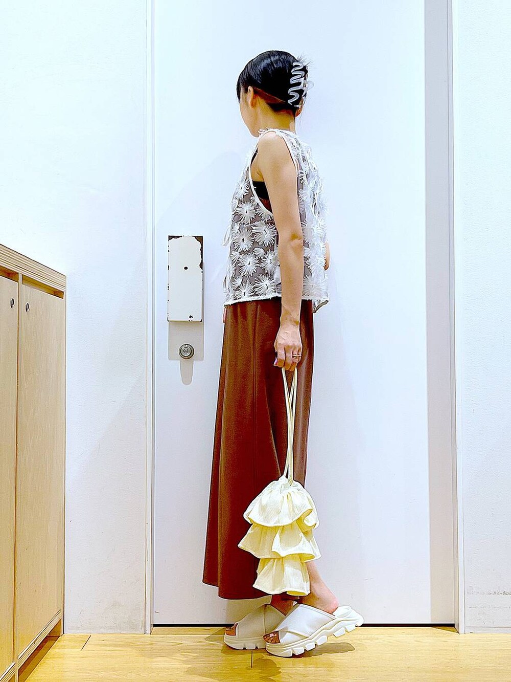 ホワイト系のサンダル、レッド系のワンピース、ホワイト系のベストを着用したレディースの夏コーディネートの3枚目の写真