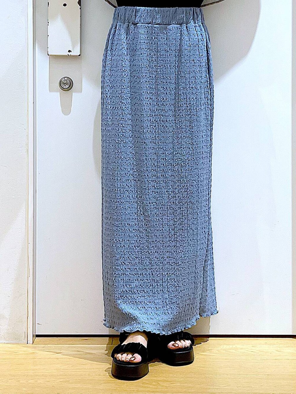 ブラック系のショルダーバッグ、ブルー系のスカート、ブラック系のTシャツ/カットソーを着用したレディースの夏コーディネートの8枚目の写真