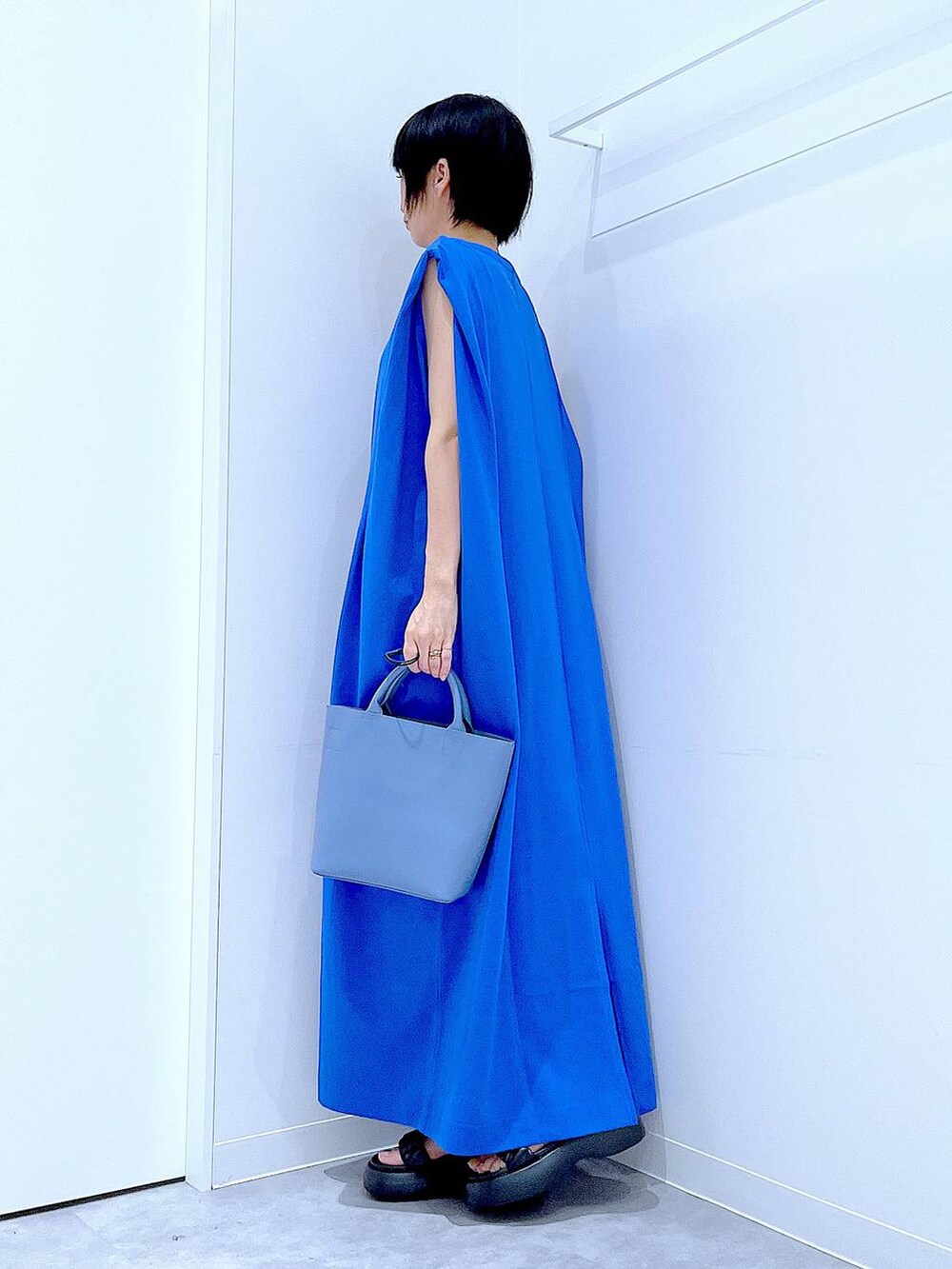 ブラック系のサンダル、ブルー系のワンピース、ブルー系のショルダーバッグを着用したレディースの夏コーディネートの3枚目の写真