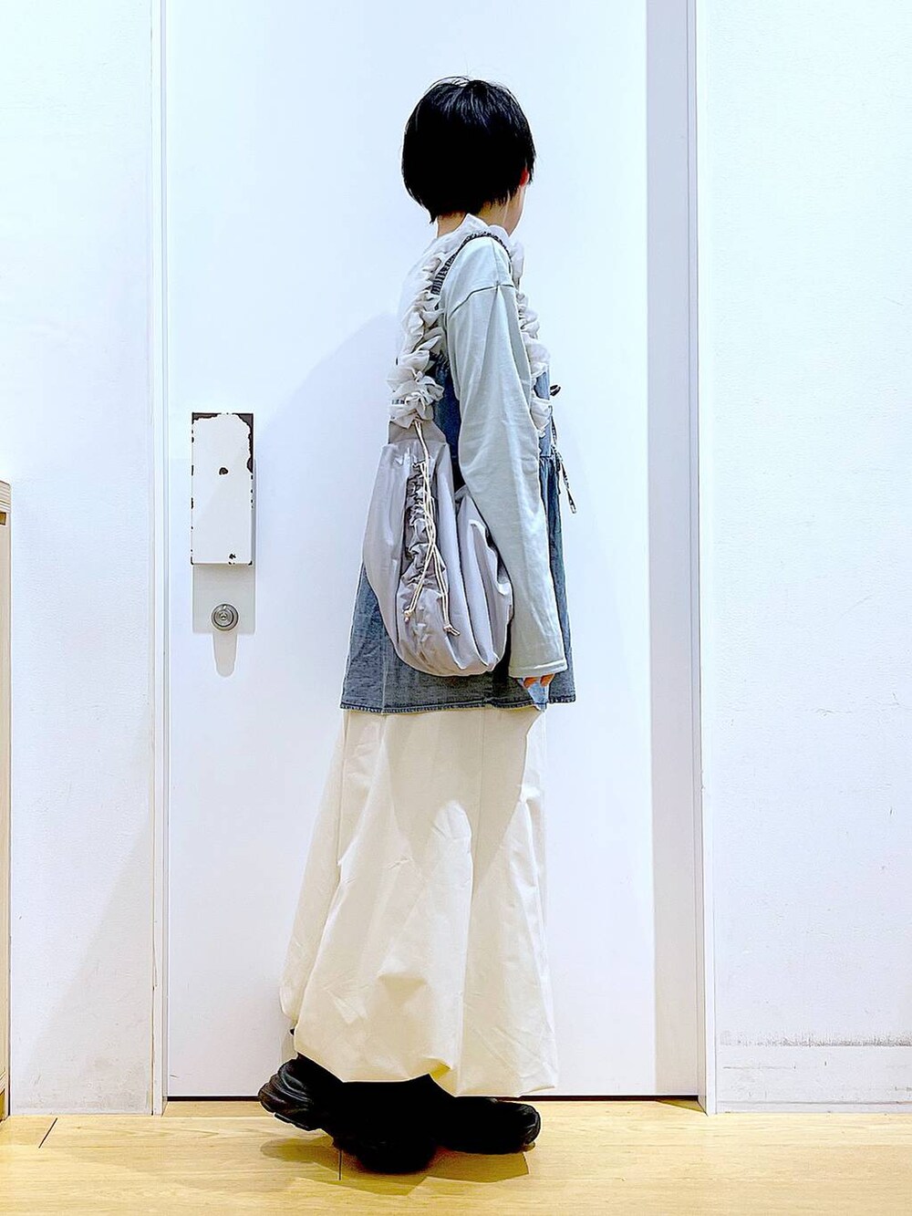 グレー系のショルダーバッグ、ブラック系のスニーカー、ブルー系のその他トップスを着用したレディースの春コーディネートの4枚目の写真