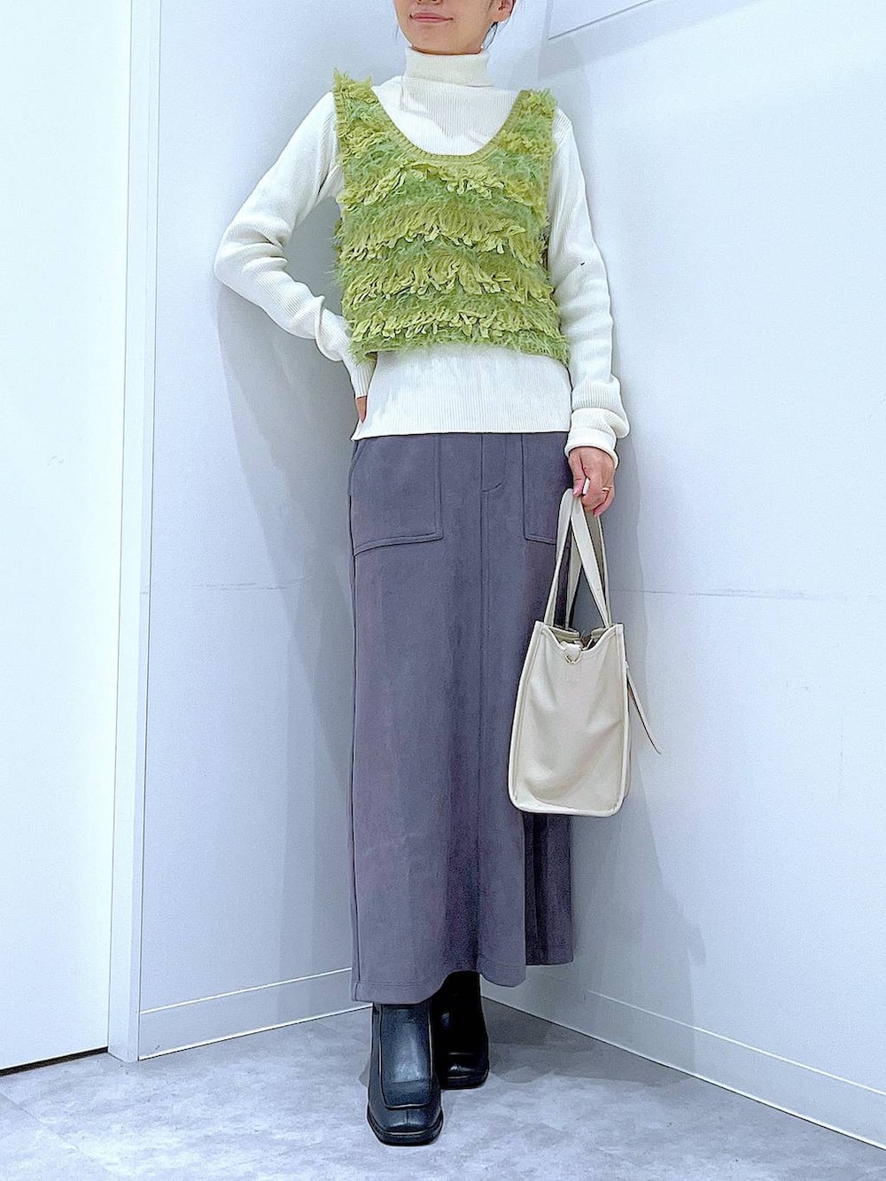 ブラック系のブーツ、グレー系のスカート、ベージュ系のニット/セーターを着用したレディースの冬コーディネートの6枚目の写真