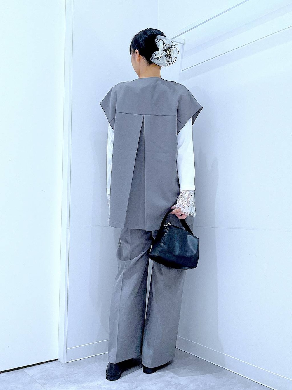 ブラック系のショルダーバッグ、グレー系のサロペット/オーバーオール、グレー系のベストを着用したレディースの冬コーディネートの5枚目の写真