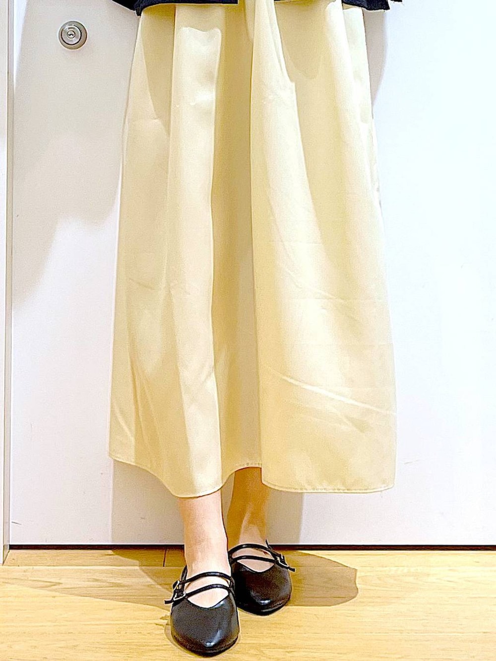 イエロー系のワンピース、ブラック系のショルダーバッグ、ブラック系のパンプスを着用したレディースの秋コーディネートの8枚目の写真