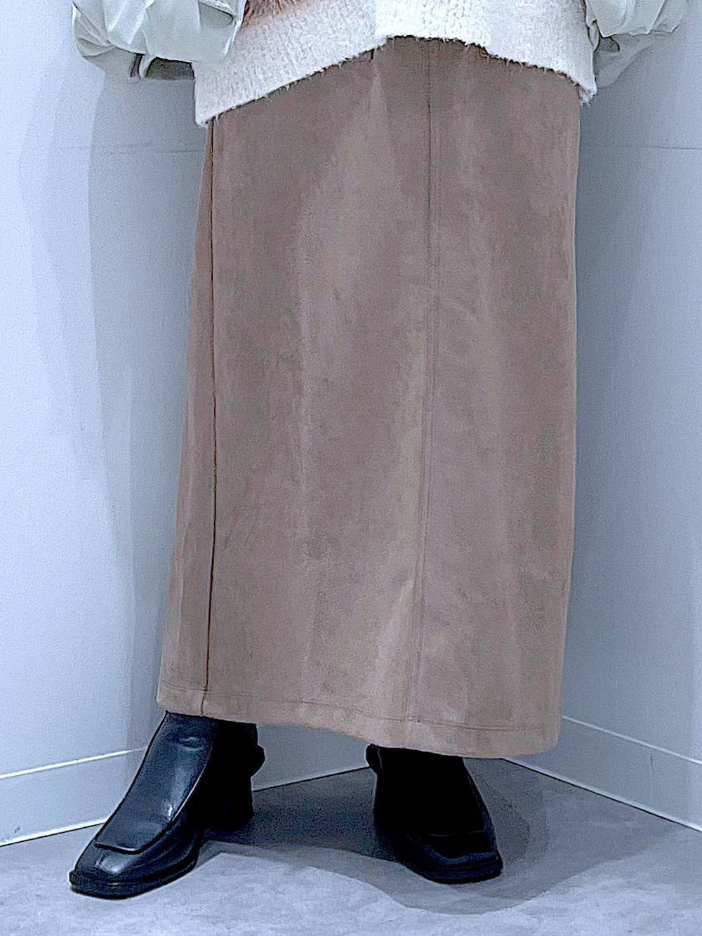 ベージュ系のニット/セーター、ブラック系のブーツ、ブラウン系のスカートを着用したレディースの冬コーディネートの8枚目の写真