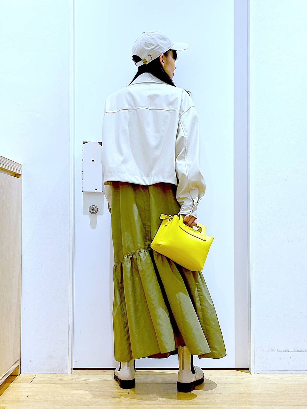 ベージュ系のブルゾン、ホワイト系のTシャツ/カットソー、ベージュ系のブーツを着用したレディースの春コーディネートの5枚目の写真