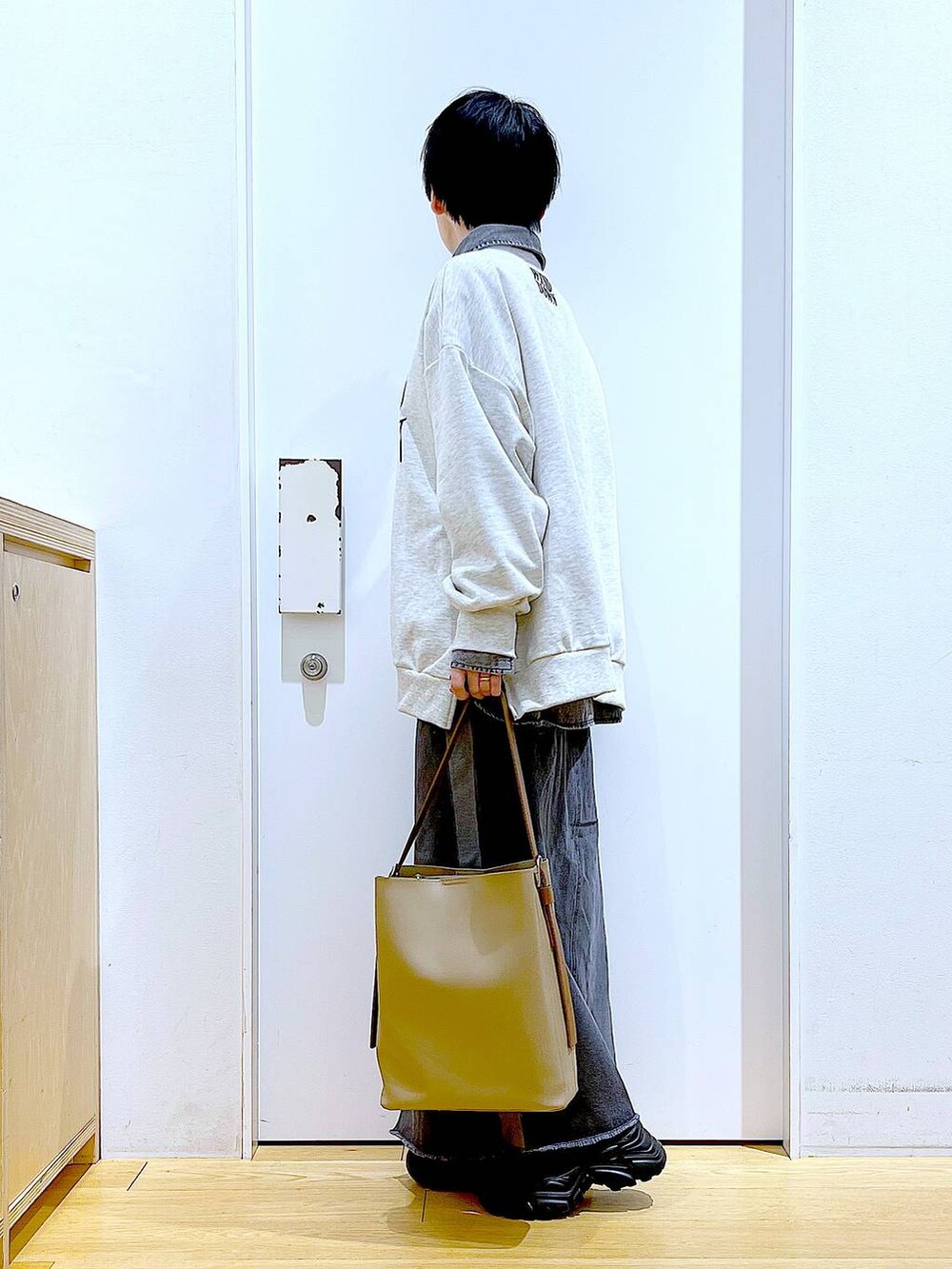 ブラック系のブーツ、グレー系のシャツ/ブラウス、ベージュ系のショルダーバッグを着用したレディースの春コーディネートの3枚目の写真