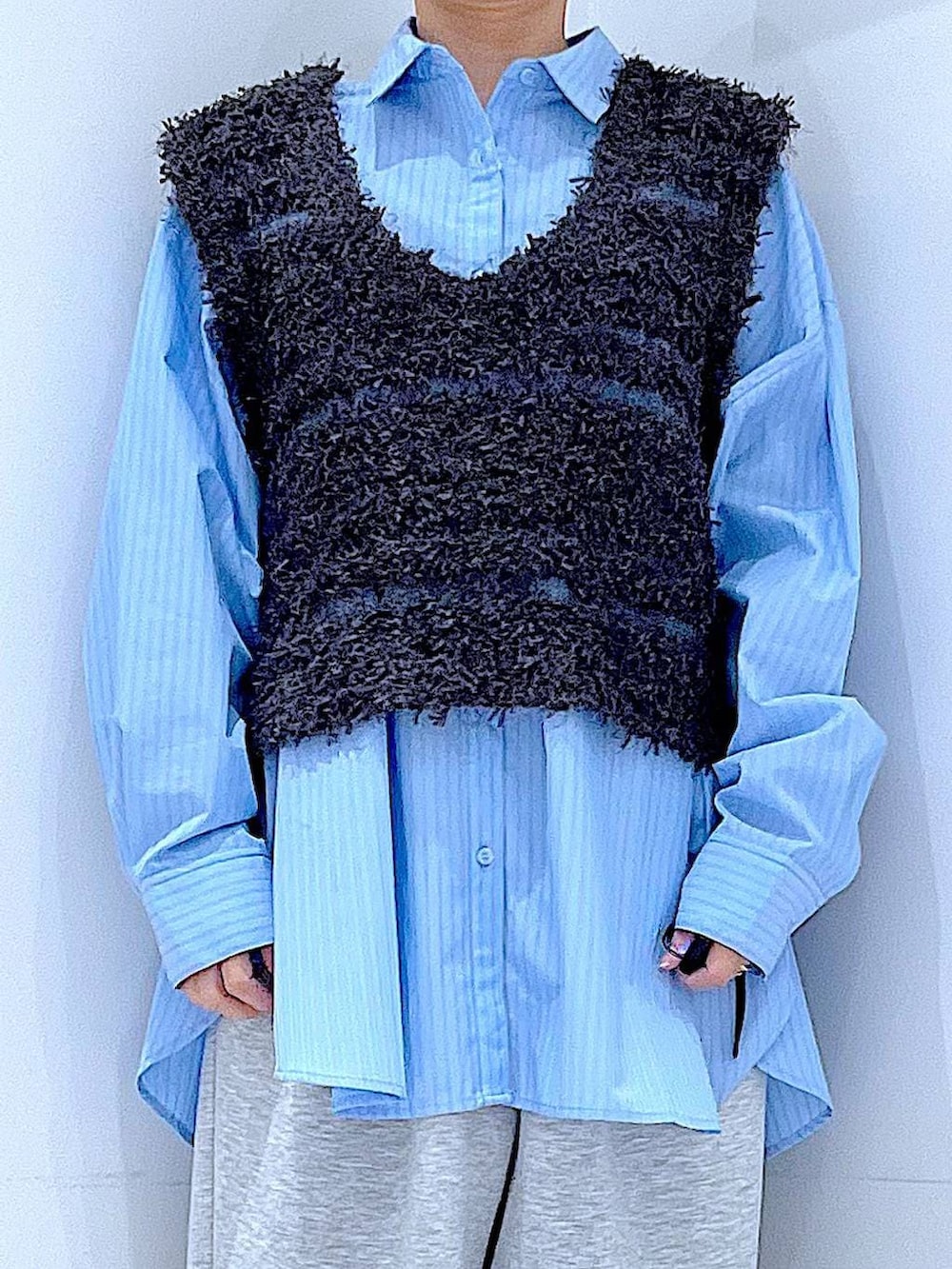 ブルー系のシャツ/ブラウス、ホワイト系のショルダーバッグ、グレー系のベストを着用したレディースの春コーディネートの7枚目の写真