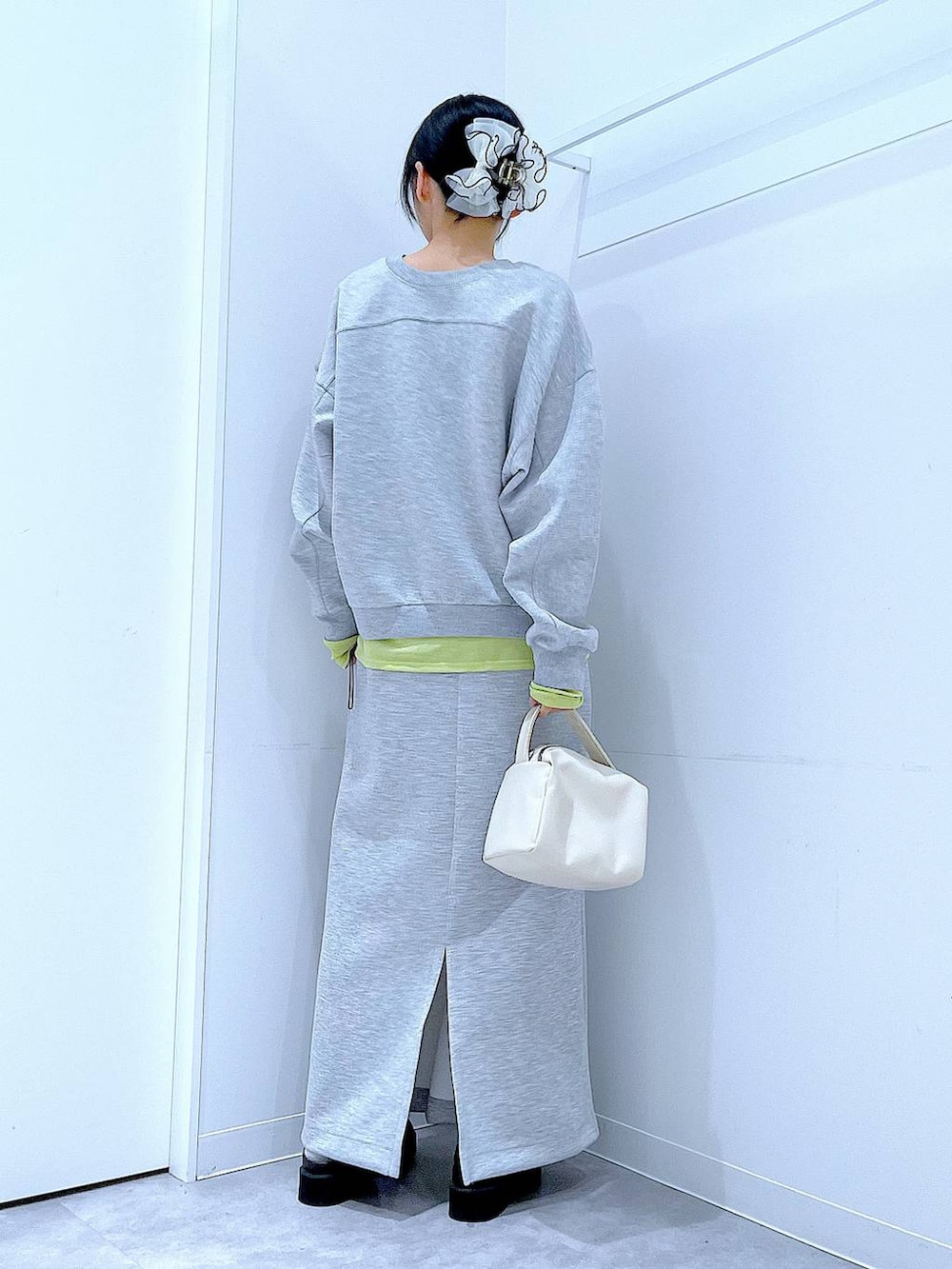 グリーン系のTシャツ/カットソー、ホワイト系のショルダーバッグ、ブラック系のサンダルを着用したレディースの春コーディネートの5枚目の写真