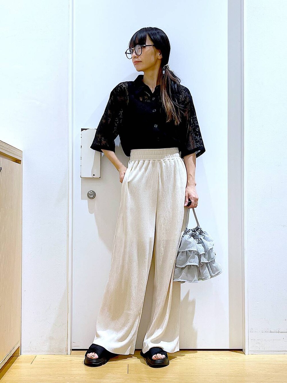 シルバー系のショルダーバッグ、ブラック系のサンダル、ブラック系のシャツ/ブラウスを着用したレディースの夏コーディネートの2枚目の写真