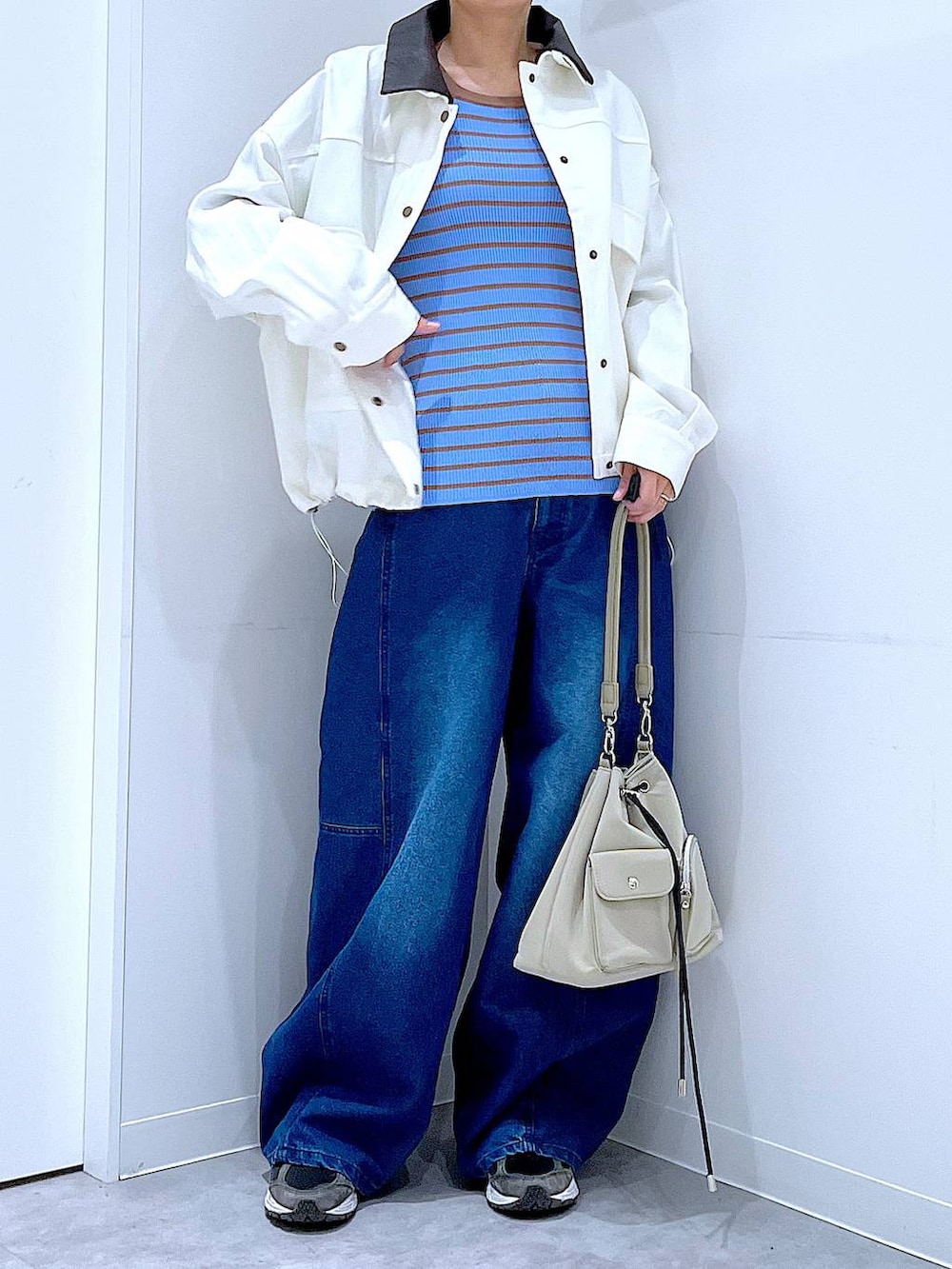 ブルー系のニット/セーター、ブルー系のデニムパンツ、ベージュ系のブルゾンを着用したレディースの冬コーディネートの6枚目の写真