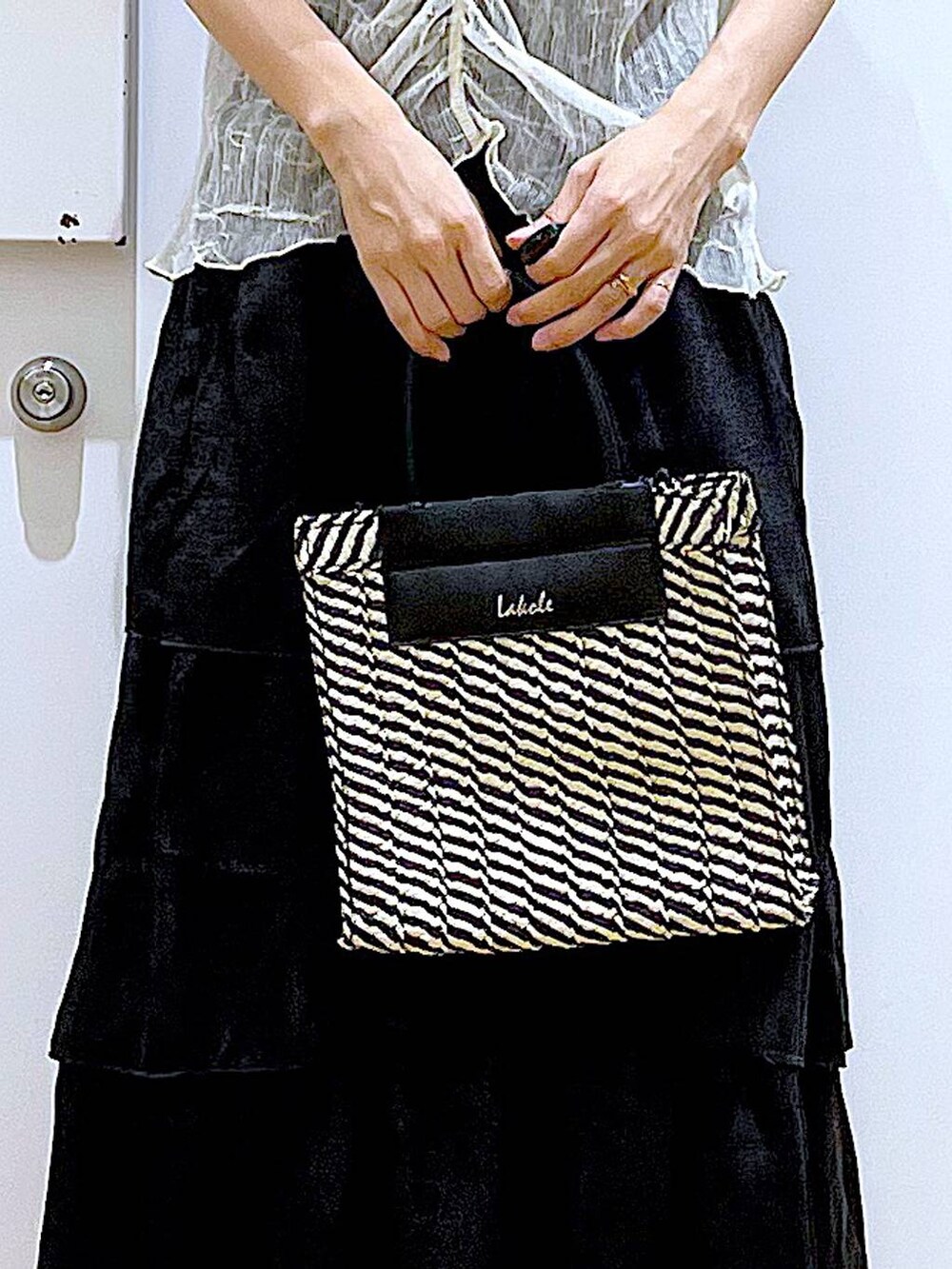 ブラック系のサンダル、ブラック系のショルダーバッグ、ブラック系のスカートを着用したレディースの夏コーディネートの9枚目の写真