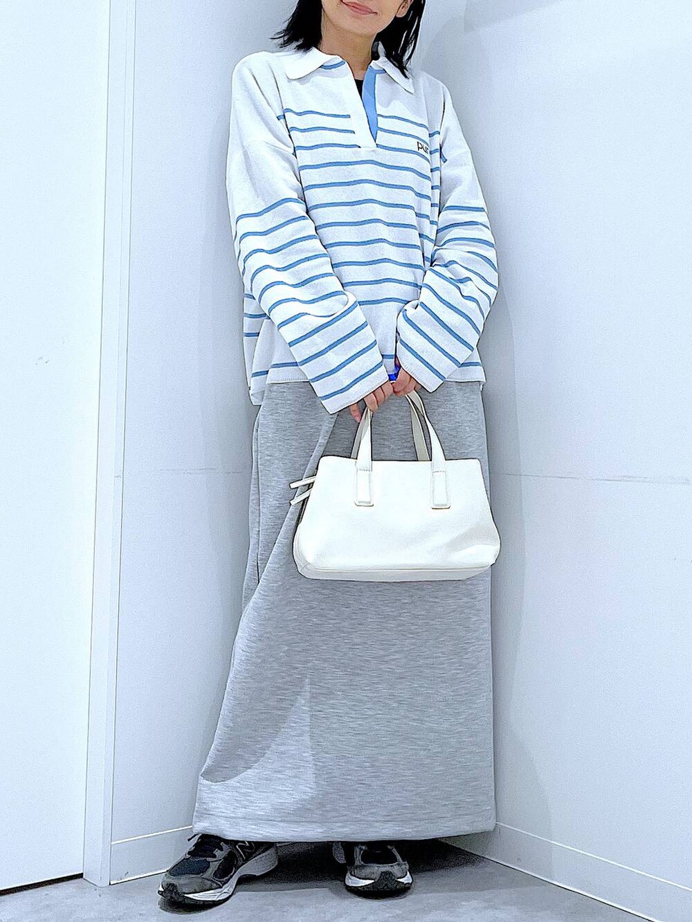 ホワイト系のボストンバッグ、グレー系のスカートを着用したレディースの春コーディネートの6枚目の写真