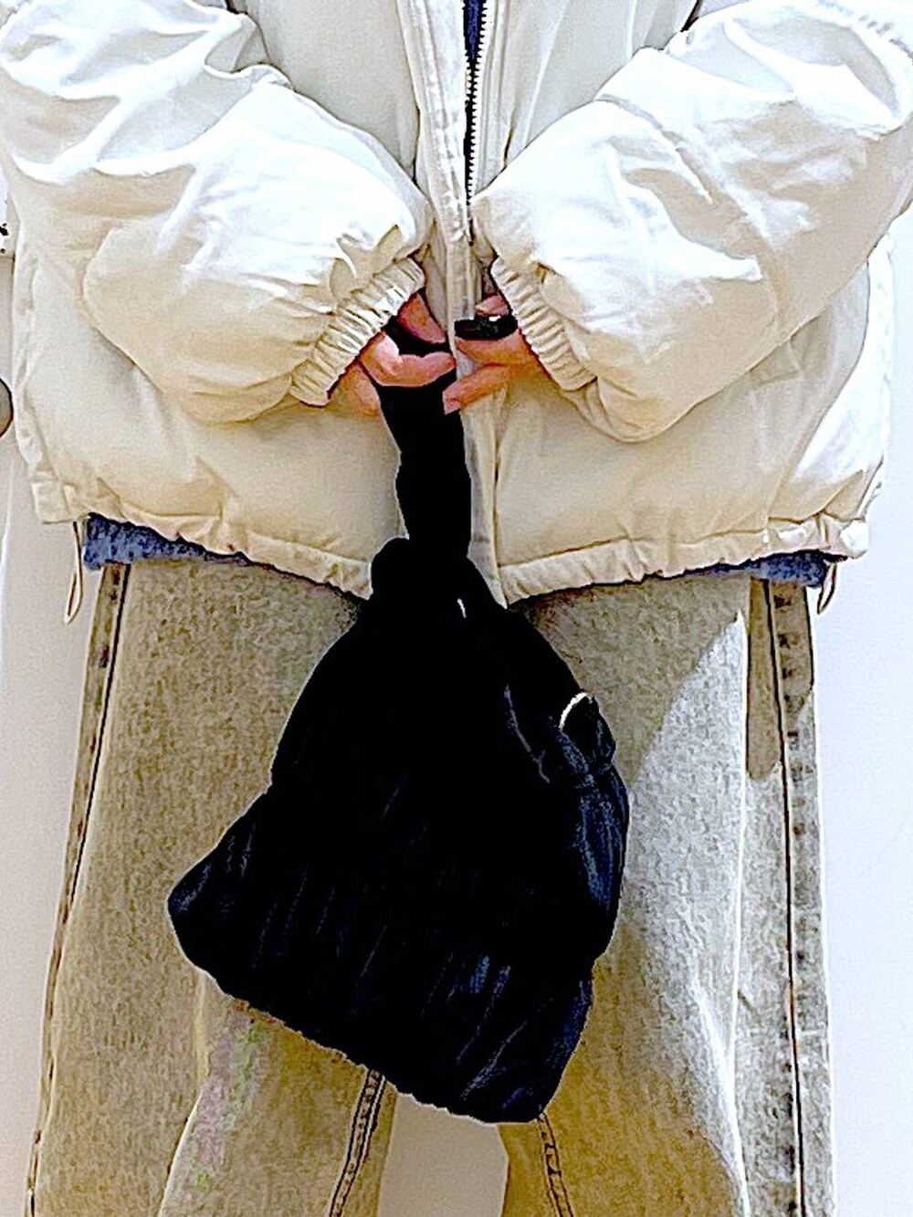 ベージュ系のブルゾン、ブラック系のショルダーバッグ、ベージュ系のデニムパンツを着用したレディースの冬コーディネートの9枚目の写真