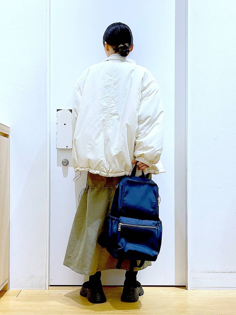 ブルー系のバックパック/リュック、ブラック系のブーツ、グレー系のスウェットを着用したレディースの冬コーディネートの5枚目の写真