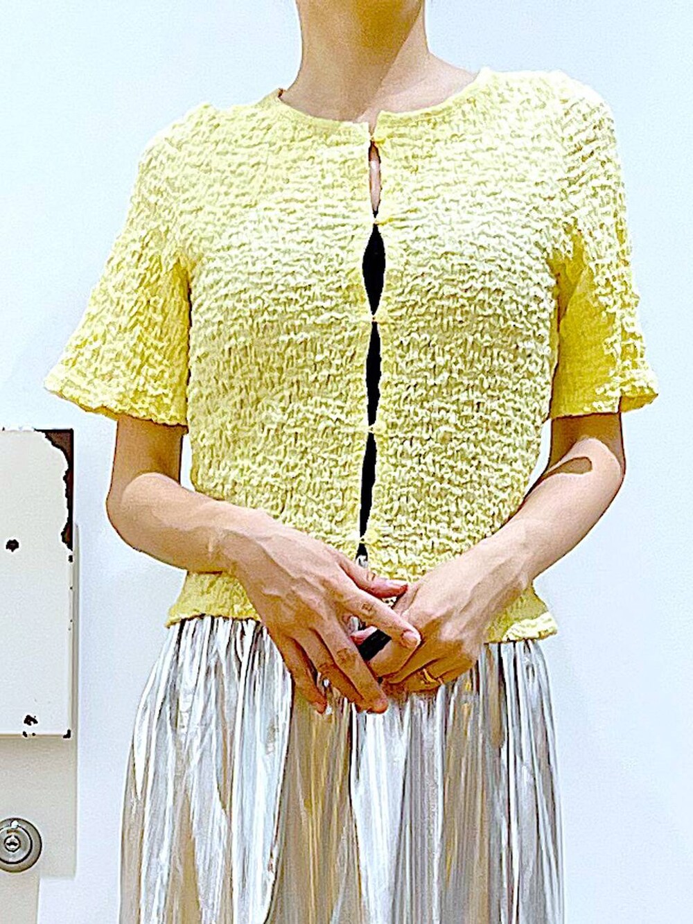 ホワイト系のサンダル、シルバー系のスカート、イエロー系のカーディガン/ボレロを着用したレディースの夏コーディネートの7枚目の写真