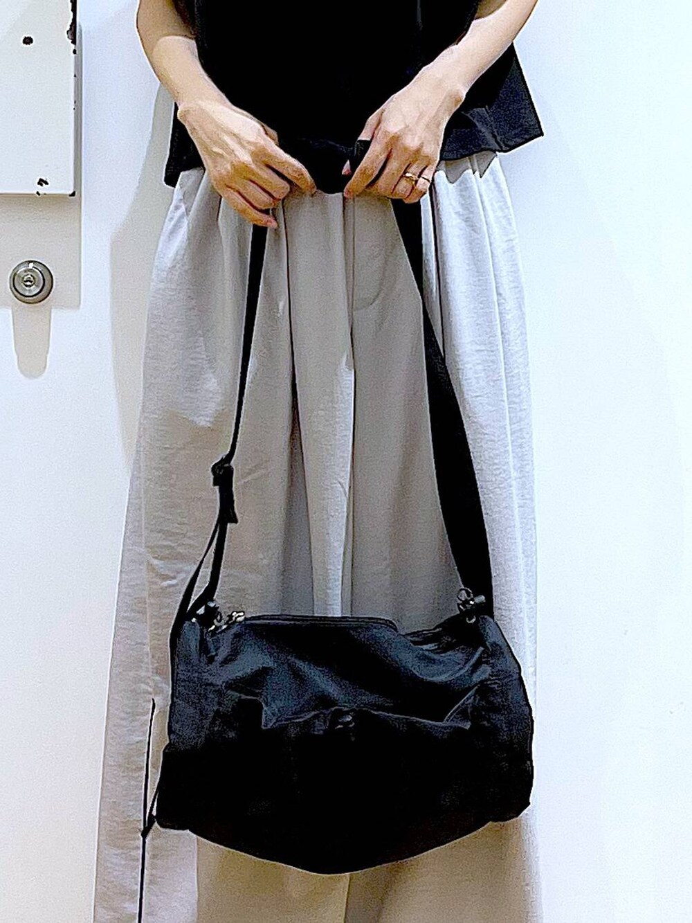 ブラック系のショルダーバッグ、ブラック系のスリッポン、ブラック系のTシャツ/カットソーを着用したレディースの春コーディネートの9枚目の写真