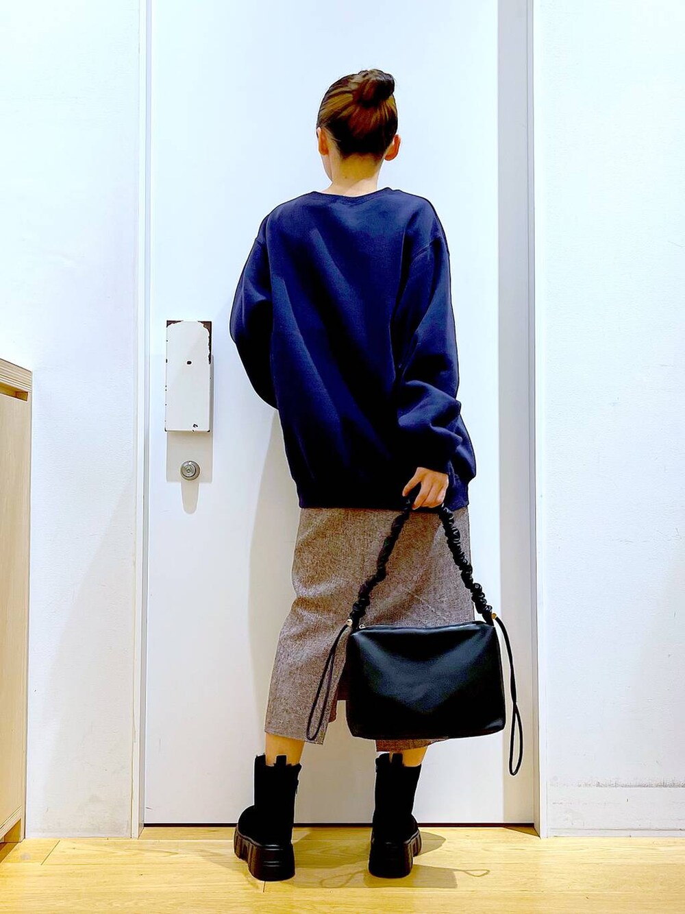 ブラック系のショルダーバッグ、ブラック系のブーツ、ブラウン系のワンピースを着用したレディースの冬コーディネートの5枚目の写真