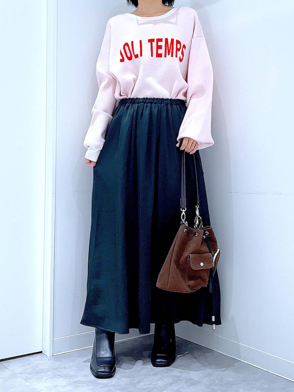 ブラウン系のショルダーバッグ、ブラック系のブーツ、ベージュ系のニット/セーターを着用したレディースの冬コーディネートの6枚目の写真