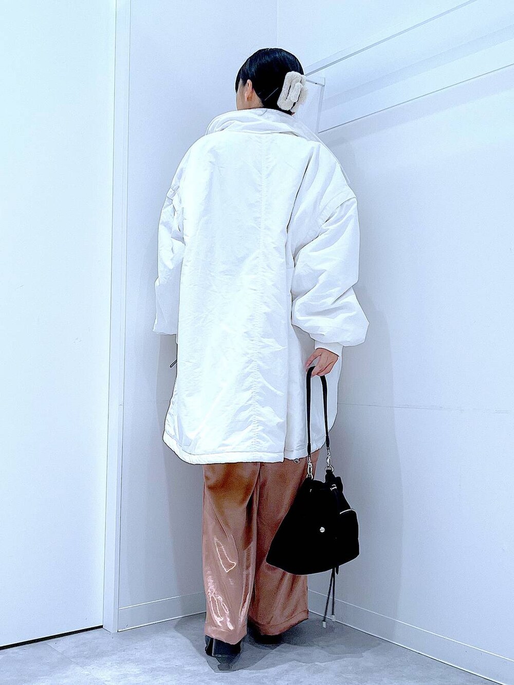 ホワイト系のブルゾン、ブラック系のショルダーバッグ、ブラック系のブーツを着用したレディースの冬コーディネートの5枚目の写真